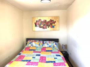 a bedroom with a bed with a quilt on it at Casa artistica CANDELARIA in Bogotá
