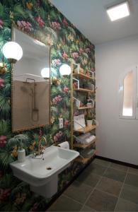 La salle de bains est pourvue d'un lavabo et de papier peint à fleurs. dans l'établissement Portolà, 1 apartament, à Balaguer