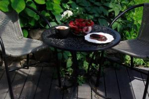 einen Tisch mit einer Schale Obst und einem Teller Kuchen in der Unterkunft Sigulda City Center Holiday House in Sigulda