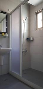baño con ducha y lavabo con puerta de cristal en JiuZhiAn Apartment, en Wujie