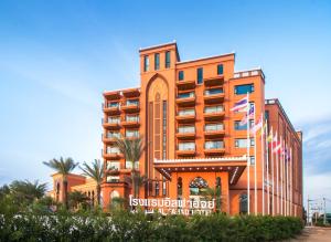 un bâtiment avec drapeaux devant lui dans l'établissement Alfahad Hotel, à Hat Yai