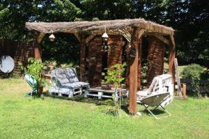 duas cadeiras e um gazebo num quintal em leschambresdanne em Chameyrat