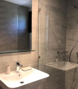 bagno con lavandino bianco e doccia di Villa Spartias a Città di Skiathos