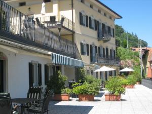 a courtyard of a building with benches and umbrellas at Residenza La Pianca in Musso