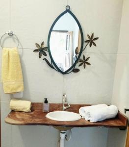 bagno con lavandino e specchio di Chalés Natora a Lençóis