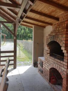 einen Backsteinofen auf einer Terrasse mit einem Holzdach in der Unterkunft Agropensiunea Cetatuia in Luncaviţa