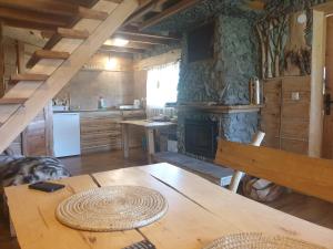 a kitchen with a wooden table and a fireplace at Domki nad Sanem in Lesko