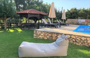 a plastic bag sitting on the grass next to a swimming pool at Villa Spartias in Skiathos