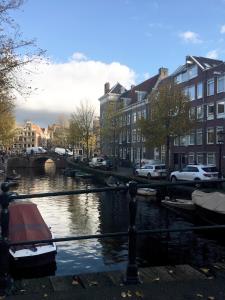 un bateau est amarré sur une rivière dans une ville dans l'établissement B&B Looier, à Amsterdam