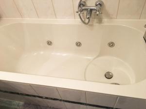 a white bath tub with a faucet at B&B Looier in Amsterdam