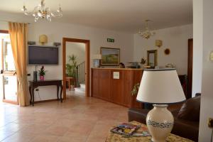 a living room with a couch and a tv at B&B "Bilha Hotel" in Le Castella