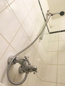 La salle de bains est pourvue d'une douche et de carrelage blanc. dans l'établissement B&B Looier, à Amsterdam