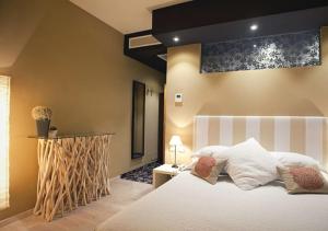 ein Schlafzimmer mit einem großen Bett mit einer weißen Tagesdecke in der Unterkunft Hotel Liberty in Levico Terme