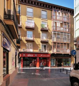 two people walking down a street in front of a building at TorreNueva in Zaragoza