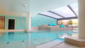 uma grande piscina com um sofá num quarto em Villa Les Quatre Vents em La Baule