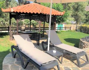 a gazebo with two chairs and an umbrella at Villa Spartias in Skiathos