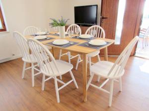 卡尼察的住宿－Lupetina，餐桌、白色椅子和电视