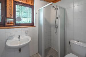 a white bathroom with a sink and a shower at Paliepgiris in Palanga