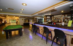 Sputnik Hotel Batumi في باتومي: يوجد بار به طاولة تنس وكراسي