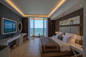 a bedroom with a large bed with a view of the ocean at Lancaster Eden Bay in Beirut