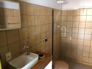a bathroom with a sink and a toilet and a shower at Sintonia do Mar in São Francisco do Sul