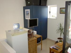 a living room with a blue cabinet and a television at Quartos Com Boas Vistas in Ribeira da Gafa