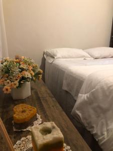 een slaapkamer met een bed en een tafel met brood en bloemen bij Sintonia do Mar in São Francisco do Sul