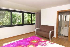 ein Wohnzimmer mit einem Stuhl und einem lila Teppich in der Unterkunft Casa Encosta do Rio-ferias no Gerês in Vieira do Minho
