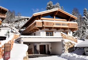 ein Haus im Schnee mit Schnee in der Unterkunft Chalet Wegmacher in Kirchberg in Tirol