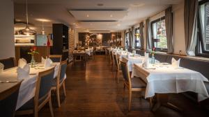 een rij tafels in een restaurant met wit tafellinnen bij Bollenhuthotel Kirnbacher Hof in Wolfach