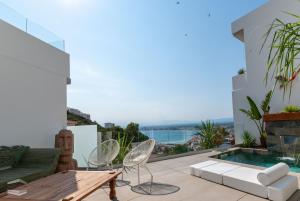 a patio with a table and chairs and a swimming pool at Vista Roses Mar - Cap Ponent in Roses