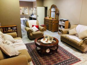 uma sala de estar com sofás e uma mesa de centro em Rooibos Retreat em Richards Bay