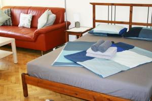 uma cama com toalhas e um sofá num quarto em Honey Home em Budapeste