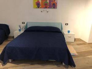 1 dormitorio con 1 cama azul y 2 mesitas de noche en Bersaglio, en Diamante