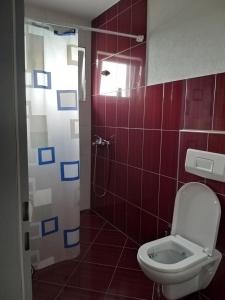 łazienka z toaletą i prysznicem z czerwonymi płytkami w obiekcie Sunrise Hotel & Camping w mieście Struga +22 zdjęcia