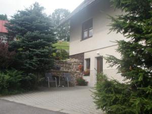 a house with two chairs and a table in front of it at APARTMÁN BERAN in Rokytnice nad Jizerou