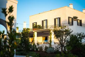 Un grand bâtiment blanc avec balcon est disponible. dans l'établissement Borgo Cozzana, à Monopoli