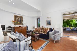 sala de estar con sofá y sillas en Amore Rentals - Villa Polifemo en Capri