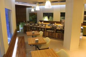 ein Restaurant mit Holztischen und -stühlen und einer Theke in der Unterkunft All-Ur Boutique Motel-Yi-Lan Branch in Yilan