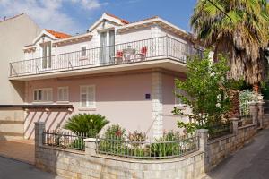 a white house with a balcony on a wall at Apartment Ambroz in Vela Luka