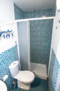 een badkamer met een toilet en een douche met blauwe tegels bij La Casa dei Nonni in Giardini Naxos