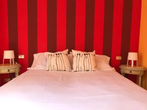 un letto con lenzuola bianche e strisce rosse e nere di Sparkling Art Como a Como