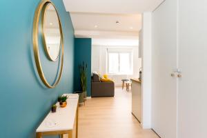 ein Wohnzimmer mit einer blauen Wand und einem Spiegel in der Unterkunft Saint-Malo With Love, Parking, Netflix, Wifi in Saint-Malo
