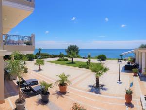 a view of the ocean from a building with palm trees at Villa Alexandros in Alexandroupoli