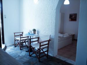 a room with a table and chairs and a bathroom at Mar-Nik Village in Paliochori