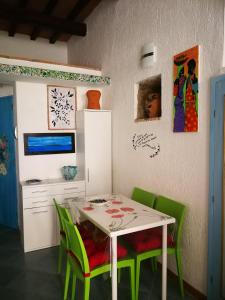 ein Esszimmer mit einem Tisch und grünen Stühlen in der Unterkunft LA PERLA in Isola del Giglio