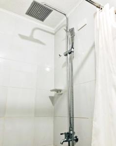 y baño con ducha y cortina de ducha. en ARC 2219 Home Rentals 2BR en Cebú