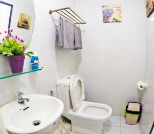 y baño con aseo blanco y lavamanos. en ARC 2219 Home Rentals 2BR en Cebú