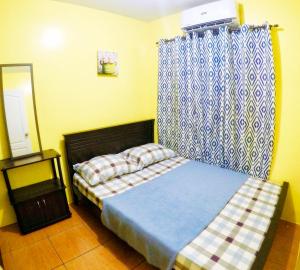Habitación pequeña con cama y cortina en ARC 2219 Home Rentals 2BR en Cebú