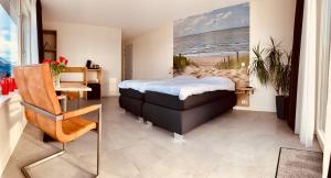 a bedroom with a bed and a table and a desk at Groede B&B in Groede